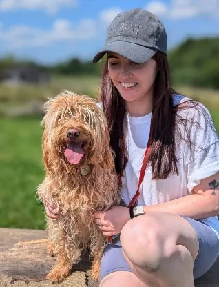 Eleisha, Operations and Admin Lead at Capital Dog Care, with a dog