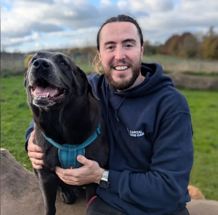 Liam, Day Care Operations Manager at Capital Dog Care, with a dog